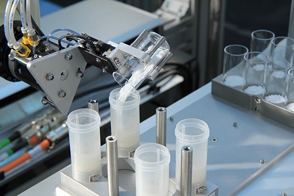 anorganisch Roboter mit geneigtem Glasfläschchen mit Pulver